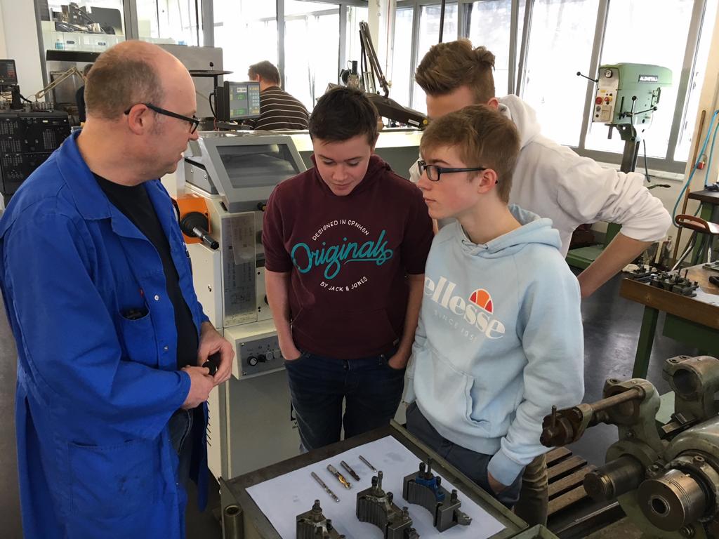 Herr Königsmann erklärt Janne, Luca und Christoph die Werkzeuge.